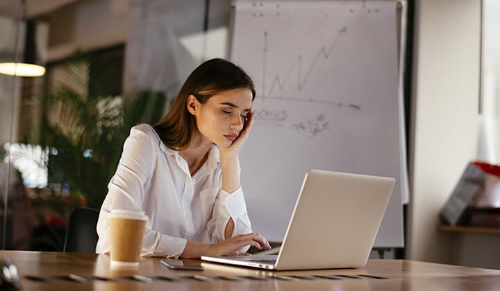 Frau schläft vorm Laptop Stress auf der Arbeit beeinflusst den Biorhythmus