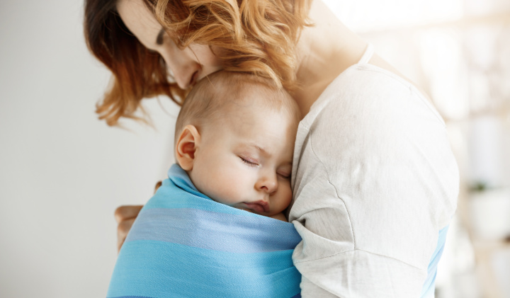 Frau mit schlafendem Baby im Arm Frau mit schlafendem Baby im Arm