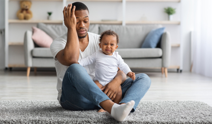 Erschöpfter Vater hält weinendes Baby Erschöpfter Vater hält weinendes Baby