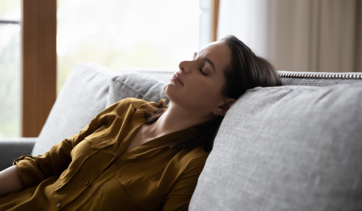Frau erschöpft auf dem Sofa