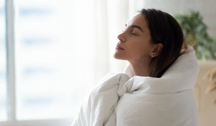 Frau mit Decke um die Schultern atmet tief durch