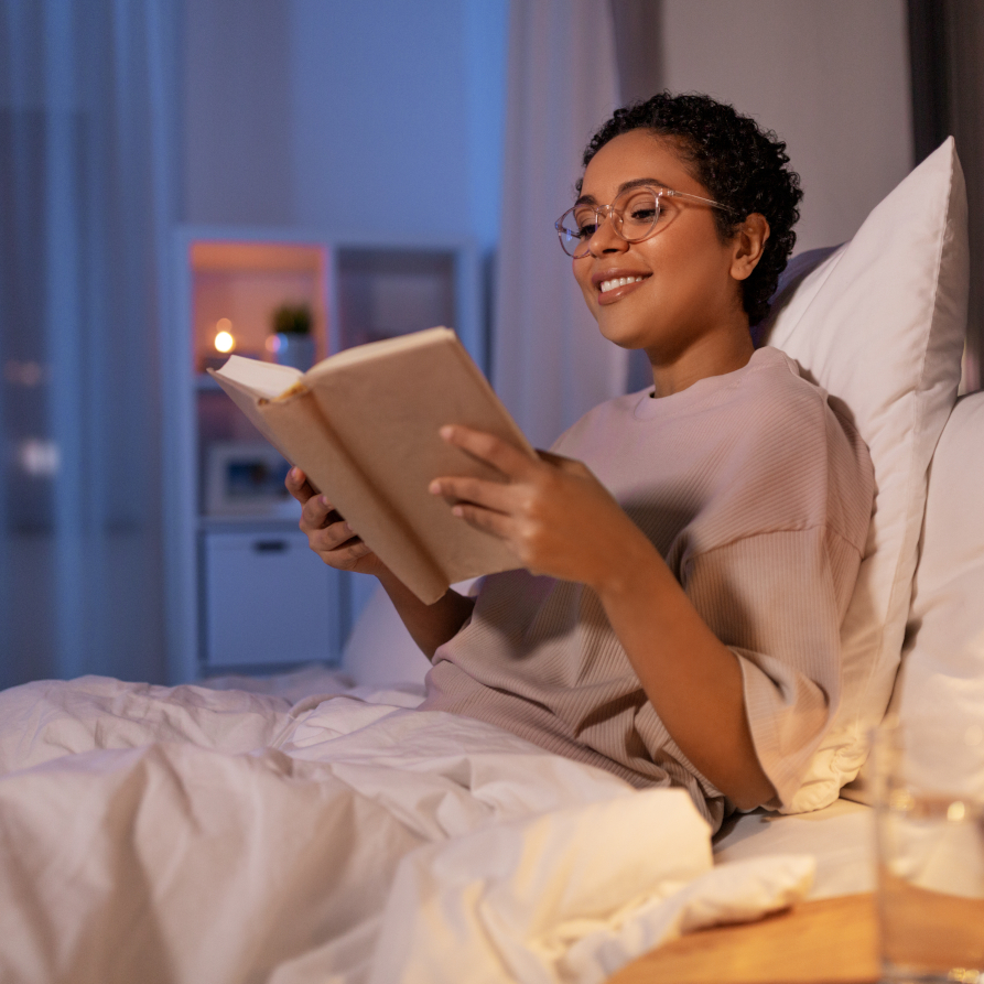 Frau mit Buch im Bett